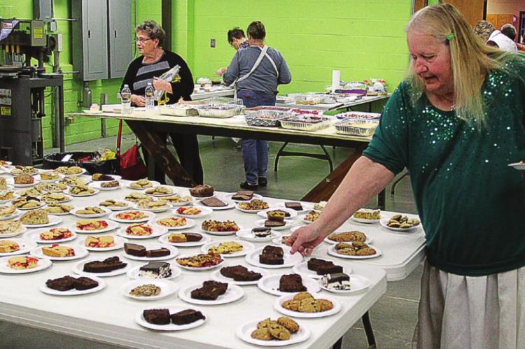 LINDA K. DOWNS makes her selection at one of the dessert tables.