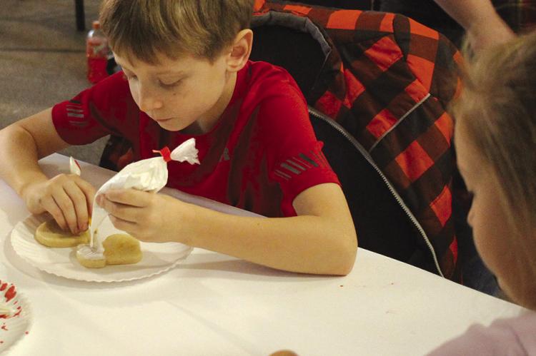LUKE (LEFT) and Alice Covey frost cookies together with their family. SOPHIA BALES | Staff
