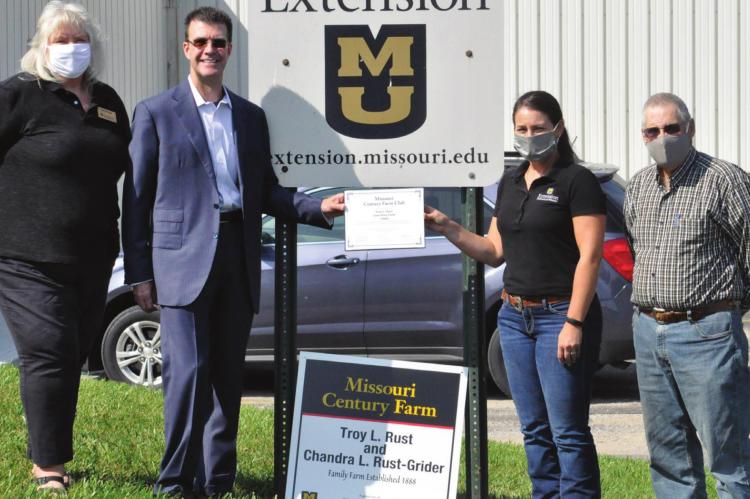 SPORTING SUNGLASSES, Troy Rust displays the certificate honoring his family farm, located near Hardin, as a Century Farm. The University of Missouri Extension and Missouri Farm Bureau provide the recognition. From left are Pam Bullock, MU Extension; Rust; Katie Neuner, MU Extension; and Jim Proffitt, Missouri Farm Bureau representative. SHAWN RONEY | Staff