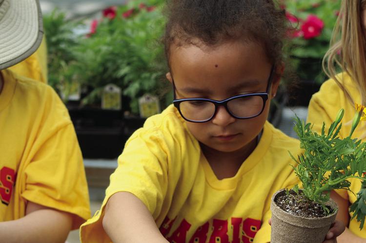 DEAR ELEMENTARY students Elena Strickler (center) and Charlee Sisson (right) learn how to properly care for plants. SHARON DONAT | Staff