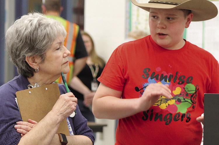 CARSON BURK (right) explains his science fair project to the judge, Janine Misenhelter. SHARON DONAT | Staff