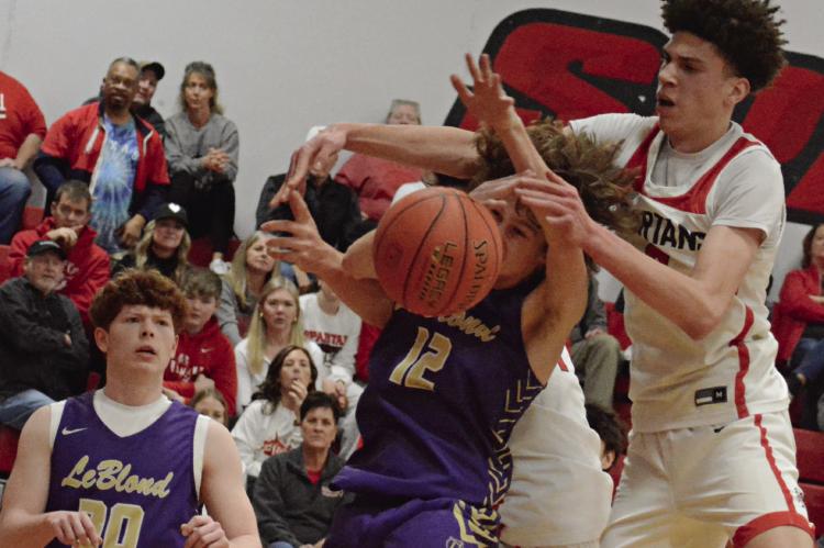 JACKSON CREWS of Bishop LeBlond (left) watches as teammate Cooper Waterman and Richmond senior Gabe Johnson (right) fight for a 50/50 ball. SHAWN RONEY | Staff