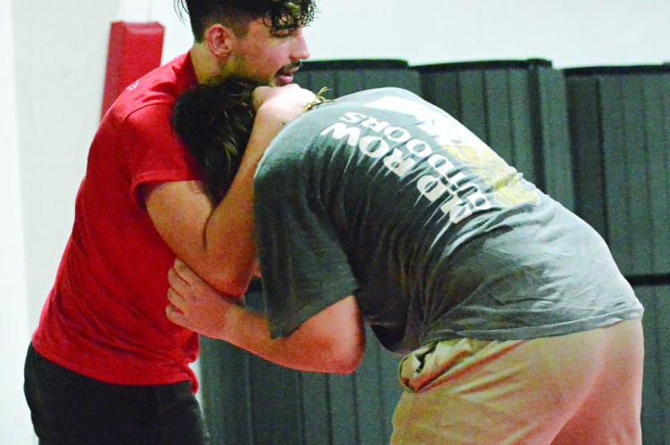 EVAN BATES (left) works on his wrestling holds during a Nov. 8 practice in the multipurpose building on the Richmond High School campus.