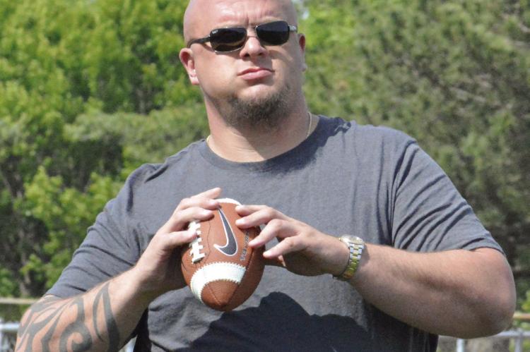 COLIN BROWN, a former pro football player and current United Methodist minister,sets to throw during warmups at Future Spartan Youth Football Camp. SHAWN RONEY | Staff