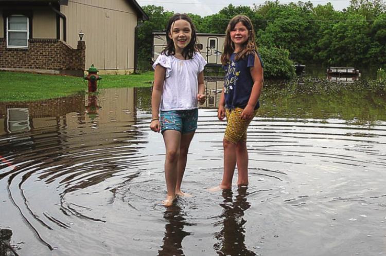 ALONG BROOKWOOD, Rylee Galariado, 7; and Tyalin Kreie, 8, stand at the new, temporary edge of Fishing River in north Richmond. J.C. VENTIMIGLIA | Staff