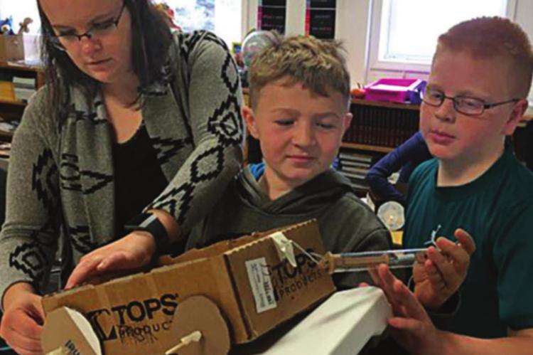 MEASURING FORCE: Julie Kreikemeier shows students in Clarkson, Nebraska, how to measure force in newtons.