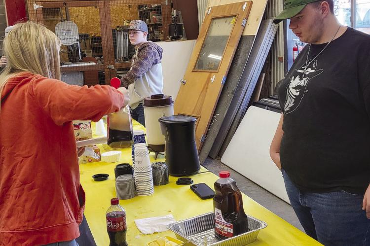 JAKE MCMILLIAN (left) and Anthony Covey serve attendees.
