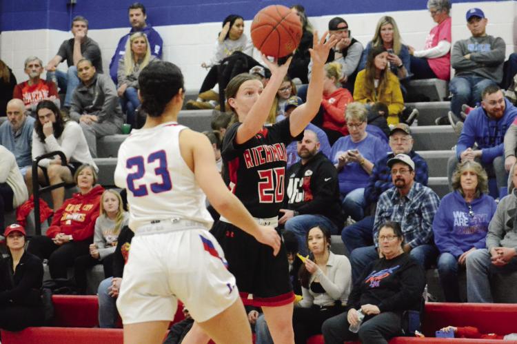 HER EYE on breaking the school record for most treys in a girls basketball game, Richmond senior Trinidy Fisk launches a long first-half jump shot as Lexington first-year high schooler Laniya Davis and many fans watch during the Spartans’ 63-41 Feb. 10 MIssouri River Valley Conference East Division road victory. SHAWN RONEY | Staff