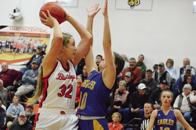 WITH NORTHWESTERN OF MENDON senior Maisy Adams guarding her and Lily Willis, a Northwestern first-year high schooler watching, Hardin-Central sophomore Zoey Polk looks to shoot during the Bulldogs’ 53-23 Dec. 15 home win. SHAWN RONEY | Staff