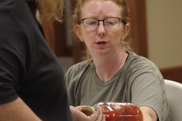 RACHELL BEACH examines jars of salsa during a canning demonstration. SHARON DONAT | Staff