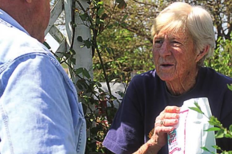 SHIRLEY BURK stands at the gate outside her house to talk with Dale.