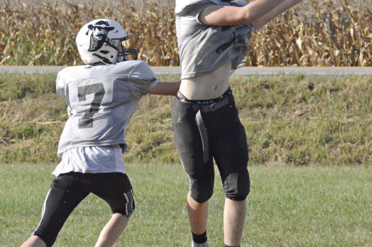 FOLLOWING HIS two-TD performance in Week 3 for Norborne Hardin-Central, Sam Barnett (right) snags a pass Monday on the Hardin-Central practice field while covered by Kaden McGinnis. SHAWN RONEY | Staff