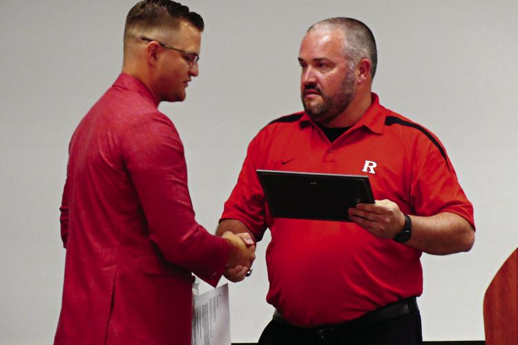HALL OF FAMER Kyle Carroll (left) gets a handshake from Brandon Quick, former Richmond coach and current Richmond High School principal.