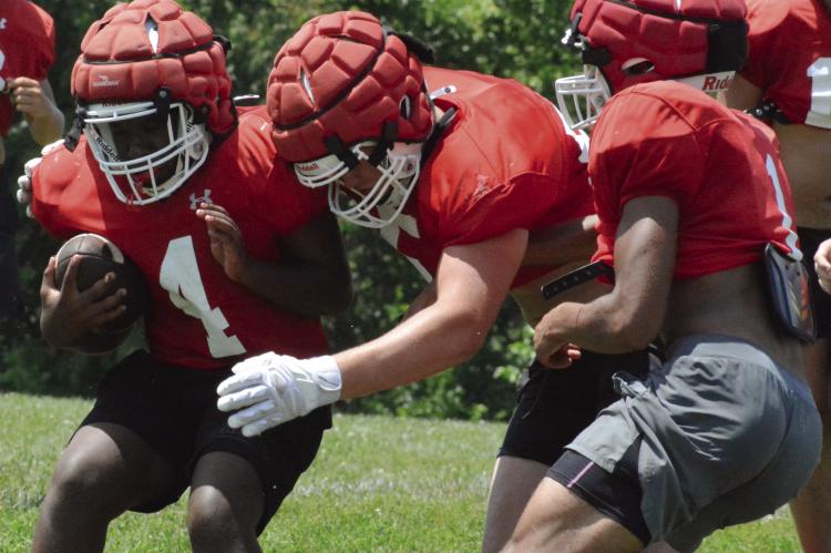 SAVION WEBB (left), an incoming freshman, braces for contact as Richmond’s offensive and defensive units scrimmage near the end of a session of team camp. Camp coverage continues below. SHAWN RONEY | Staff