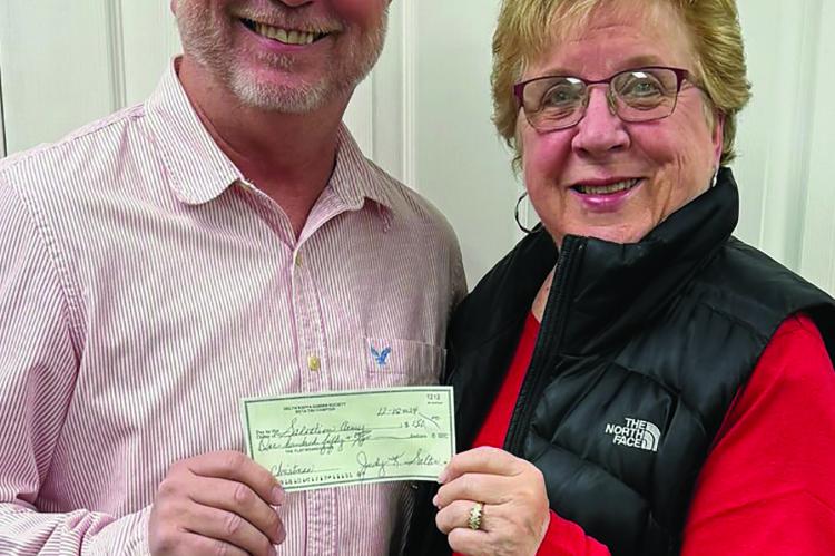 BETA TAU TREASURER Judy Salter presents a donation to Salvation Army Director Phil Powers (left). Submitted
