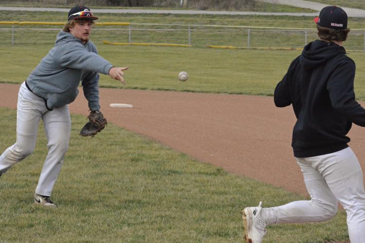 JUNIOR JACOB LIEBERKNECHT (left) flips the ball toward first base after fielding a bunt.