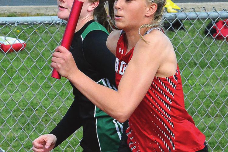 WITH THE BATON held high and the wind befriending her, Richmond sophomore Kaylee Pugh buzzes down the front straightaway as she runs the second leg of the girls 400-meter relay April 22 at Excelsior Springs. SHAWN RONEY | Staff