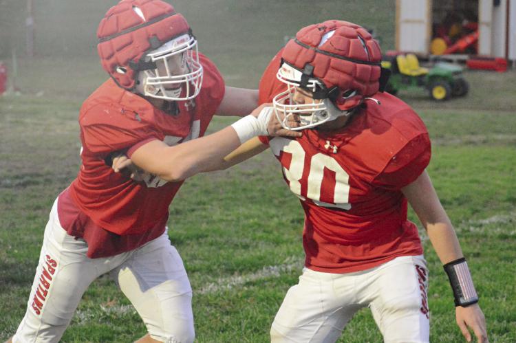 TRISTIN McCOY (left) blocks teammate Colton Hewlett on Richmond’s practice field as the Spartans prep to face Cameron Friday night in district play. SHAWN RONEY | Staff