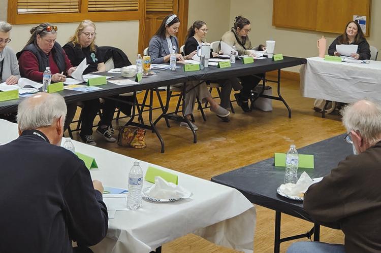 RAY COUNTY COALITION members examine prevention handouts and meeting materials while discussing policy, enforcement and community education initiatives. MIRANDA JAMISON | Staff