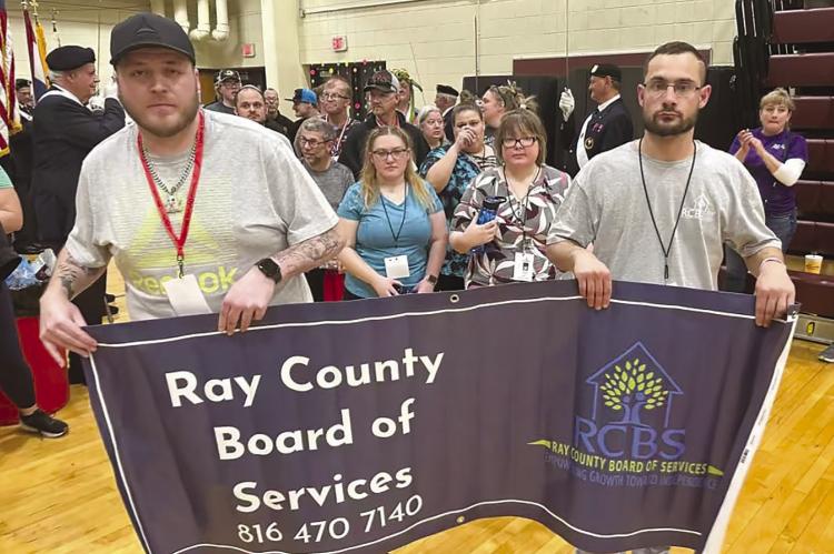 RAY COUNTY ATHLETES Caleb Shockey (left) and Cody Stevens escort the 10 other Special Olympic participants to the indoor games. Submitted