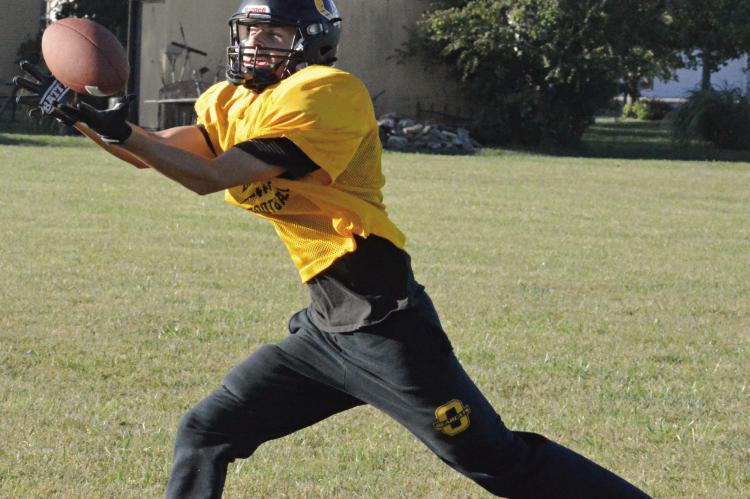 PARKER FLOYD reaches out to snag a pass Monday morning on Orrick’s practice field, as he and his fellow Bearcats prep for Friday’s homecoming meeting with Sweet Springs at Simmons Field in varsity 8-man football. SHAWN RONEY | Staff