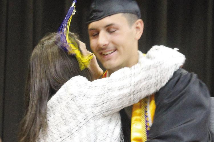 PARKER FLOYD embraces his mother, Board of Education member Mandy Floyd, after receiving his diploma during Orrick High School commencement ceremonies. MIRANDA JAMISON | Staff
