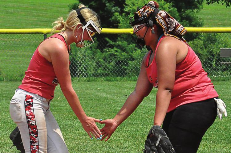 SENIORS KAYDEN McCARTER, left, and Mykayla Thaxon exchange a low-five during Richmond’s softball camp. SHAWN RONEY | Staff