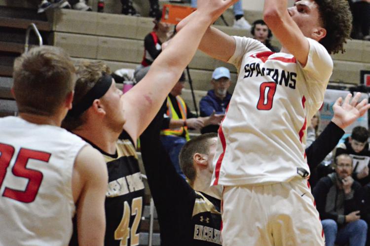 RICHMOND JUNIOR Gabe Johnson shoots over the outstretched left hand of Excelsior Springs junior Cooper Bishop Monday night in Winter Classic action at Richmond Middle School. SHAWN RONEY | Staff