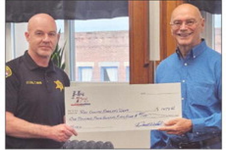 HERO FUND USA CEO Darrell Smith (right) presents Ray County Sheriff’s Office Lieutenant Colonel Tom Noon with funding toward the purchase of a new mobile radio. MIRANDA JAMISON | Staff