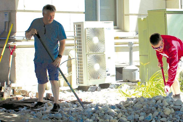 MIKE CHOWNING (left) and son, Caleb, distribute rocks around the county courthouse. SHARON DONAT | Staff