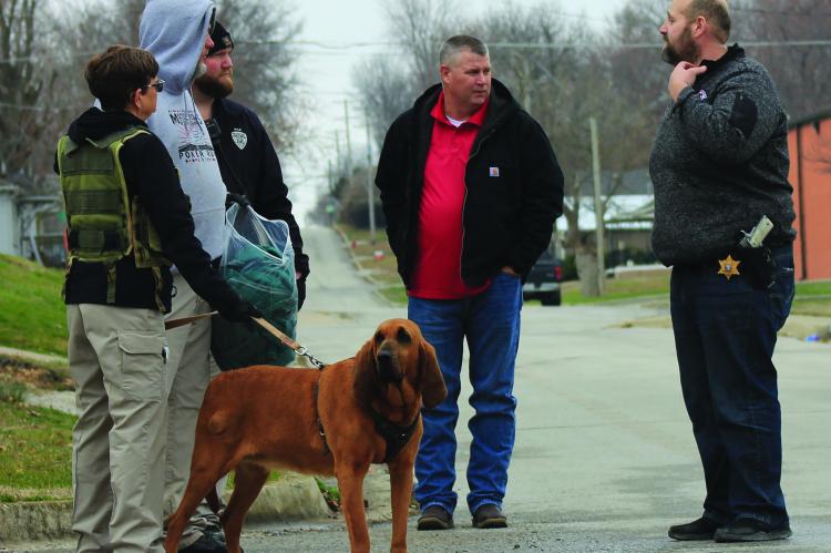 WESTERN MISSOURI CORRECTIONAL Center K9 Unit division personnel are in the area with a bloodhound, Molly, holding a bag of Justin Robinson’s clothing. Presiding Commissioner Billy Gaines and Ray County Sheriff Scott Childers discuss the next steps in finding Robinson, who escaped from the Ray County Jail Monday night. SOPHIA BALES | Staff