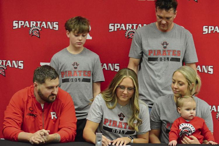 RICHMOND SENIOR Isabella Smith signs her letter of intent to play women’s golf at North Central Missouri College, surrounded by members of her family. Also pictured are (from left), front row, Jordan Smith, Nora Boguskie and Stephanie Williams-Boguskie; back row, Brady Boguskie and Jeff Boguskie. SHAWN RONEY | Staff