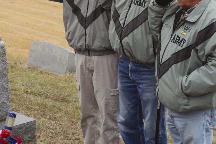 WAYNE WALTON (from left), Bruce Biggs and Richard Blair salute Forrest Dickey’s grave in silent tribute to a life lost in battle. SHARON DONAT | Staff