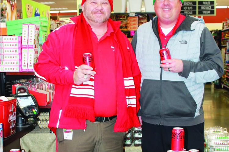 Coca-Cola representatives Mike McCarter (left) and Eric Caldwell (right) handled the soda tasting area while conducting a raffle for Ray County customers.