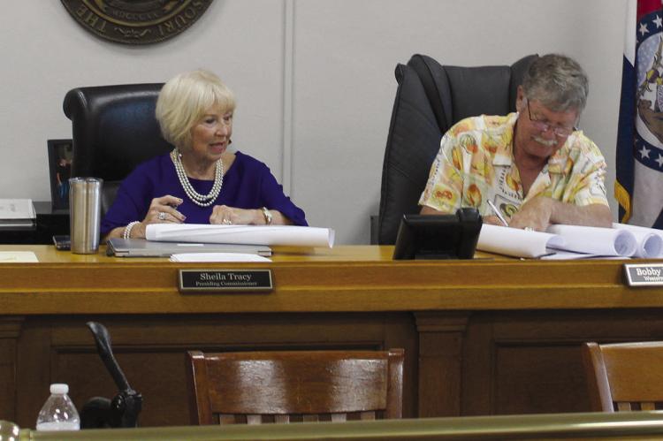 PLANNING AND ZONING Administrator Stacy Wolfe (right) presents subdivision plats to commissioners for review and signatures. MIRANDA JAMISON | Staff