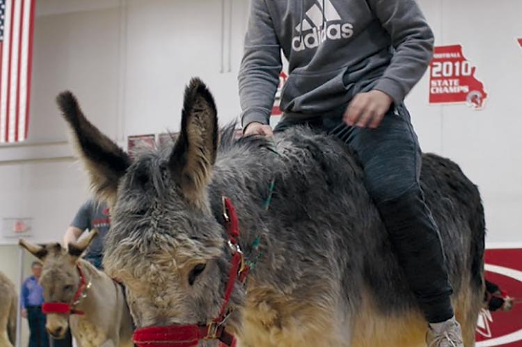 RHS STUDENT RICKY RUSS entertains the crowd as he rides a donkey and plays basketball. Submitted