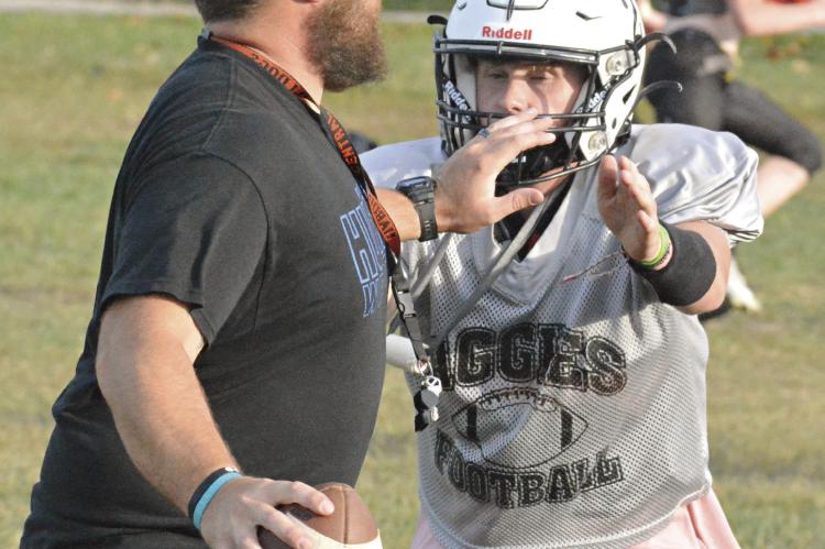 THIRD-YEAR COACH Andrew Watson, sporting his shades and ballcap while fending off pass rusher Zach Deitch during a September practice, has his first victory over Missouri Highway 10 rival Orrick in varsity 8-man football. SHAWN RONEY | Staff