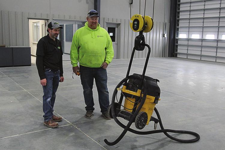 INSIDE the new Ag-Power building that is almost ready to open at Highways 210 and 10, parts manager Curt Calvert and Septagon’s Dave White demonstrate how easily the overhead crane operates. J.C. VENTIMIGLIA | Staff