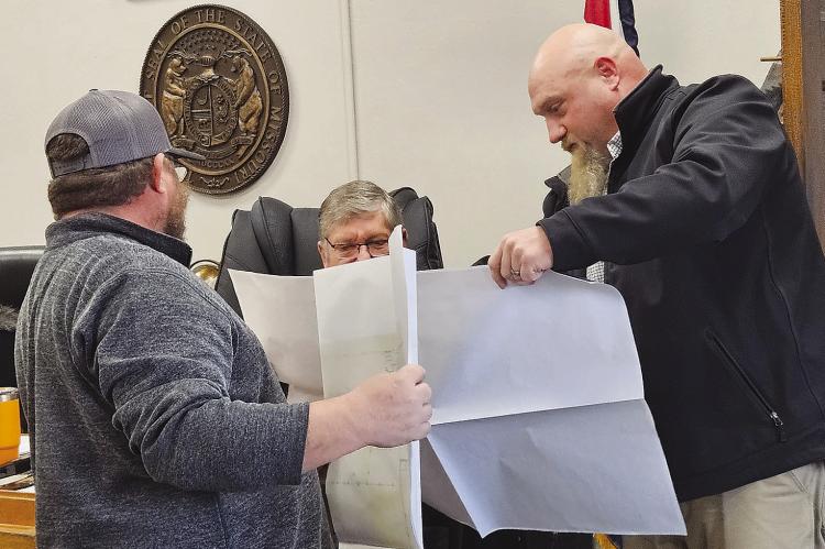 GREEN HILLS COMMUNICATIONS plant manager Chris Shoe (right) and Commissioner Bobby Don Davis review a map detailing copper infrastructure upgrades needed to support increasing demand for fiber-optic internet. MIRANDA JAMISON | Staff