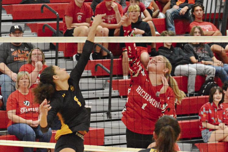 ANELA FLETCHER of Orrick (left) and Addison Burk fight for control at the net as the crowd watches Sept. 12 at Richmond High School. SHAWN RONEY | Staff
