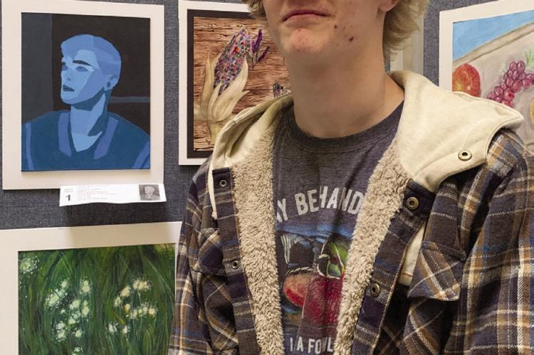 GUNNER SMITH stands near his monochromatic self-portrait. His favorite part about going to the Capitol with his peers and teacher was seeing all the other art, he said.