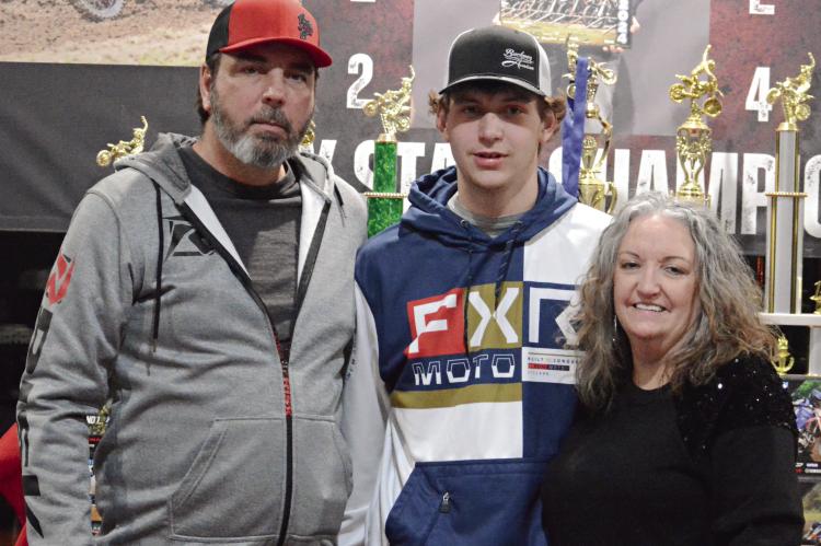 XANDYN TAYLOR (center) of Richmond enjoys the spoils of his victories as a motocross racer during a party thrown by his parents (from left), Jamie and Tamara Taylor. Look for additional coverage of the Taylors’ celebration March 7. SHAWN RONEY | Staff