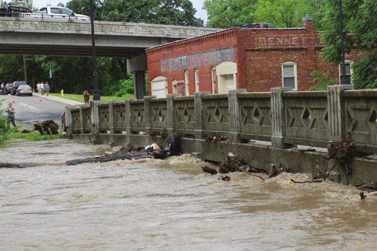 FLOOD WATER from the Fishing River reaches the bottom of the Marietta Street Bridge in downtown Excelsior Springs on June 25. Flooding forces cancellation of the 2021 Waterfest.