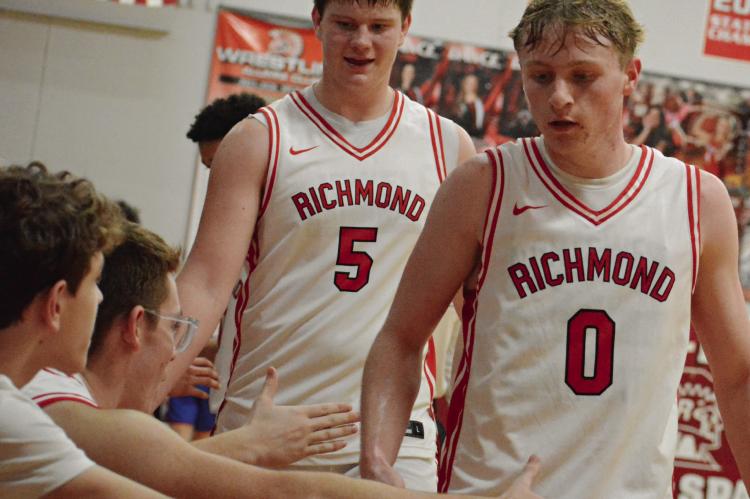 BRODY FARNAN (center) and Nolan Quick (right) exchange low fives with their teammates as they leave the court during the second half of Richmond’s courtwarming meeting with Lexington. SHAWN RONEY | Staff