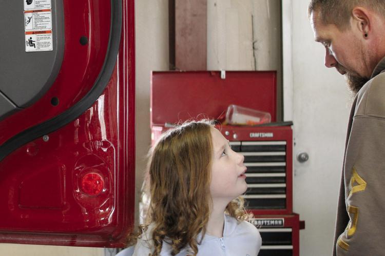 RUBY MARSHALL and her dad explore fire trucks during event festivities. MIRANDA JAMISON | Staff