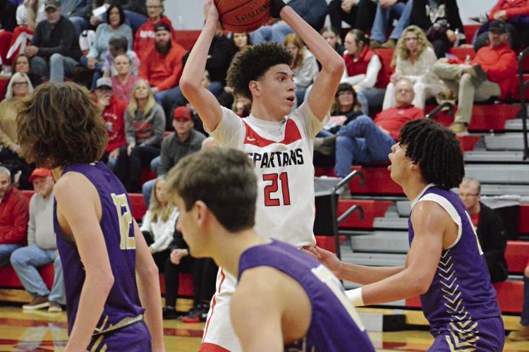GABE JOHNSON protects the basketball by keeping it above his head as he looks to pass during the second half of Richmond’s Winter Classic title game with Bishop LeBlond of St. Joseph Jan. 27 at Richmond High School. SHAWN RONEY | Staff
