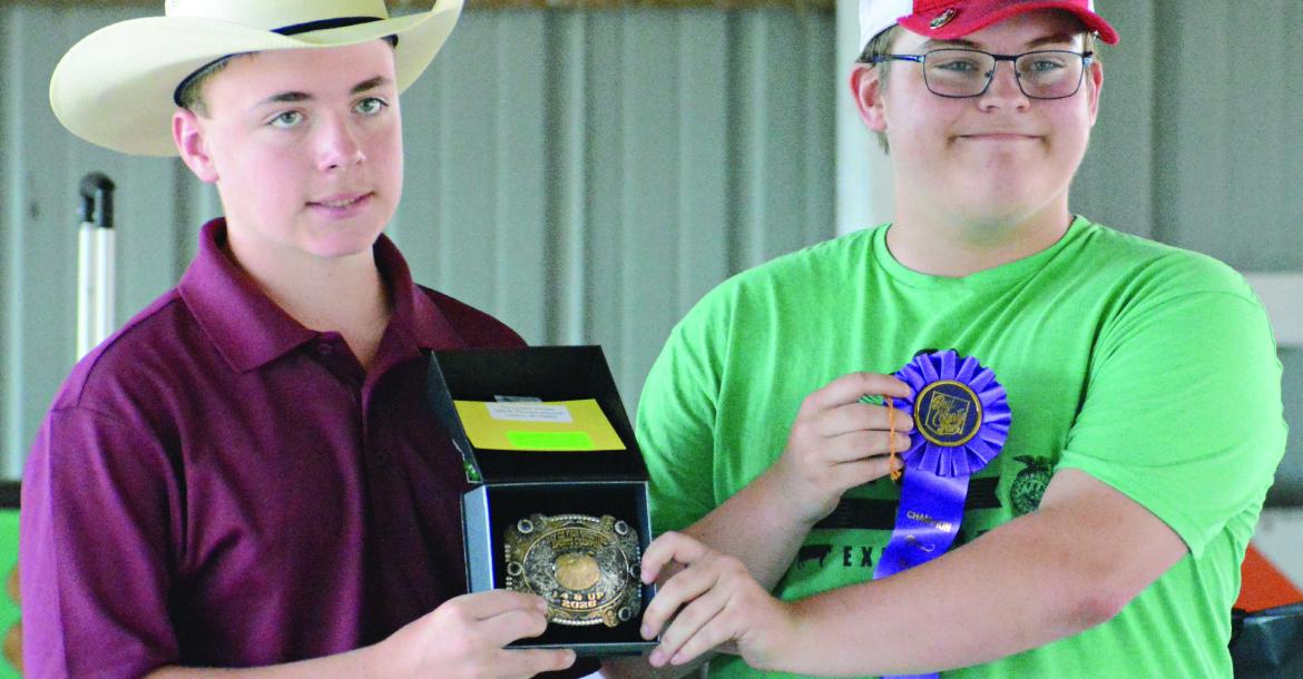 WESTON COVEY (left) helps display hardware won by Hunter Crowley in shooting sports during this year’s Ray County Fair in Richmond. SHAWN RONEY | Staff