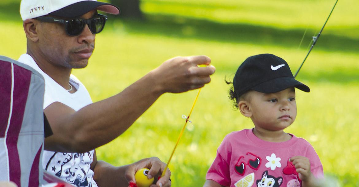 TEVIN ROBINSON helps his daughter, Maven, prepare her fishing line during the fishing competition. SHARON DONAT | Staff