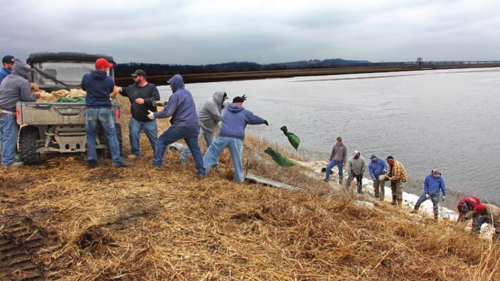 NEAR THE ROUTE J bridge, volunteers work in 2019 to prevent the Missouri River and Crooked River from destroying the levee. Flood water pounds the levee for days, but with volunteer help, the levee holds. J.C. VENTIMIGLIA | Staff