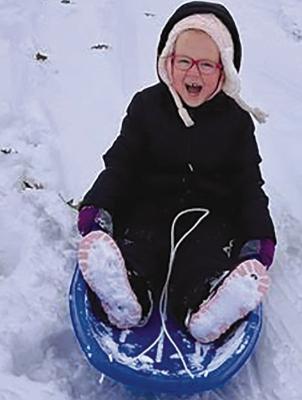 EVELYN BURKEYBILE (front) sleds down, yelping with snowy joy. TIFFANY BURKEYBILE | Submitted